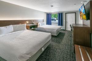 a hotel room with two beds and a television at Gatlinburg Mountain Inn in Gatlinburg