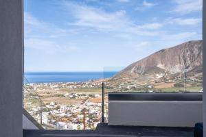 - une vue sur la ville depuis une fenêtre donnant sur la montagne dans l'établissement Deep Earth Villas, à Éxo Goniá