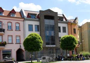 Un edificio con persone sedute di fronte ad esso di Atmosfera Apartament 1 i 2 a Bytów