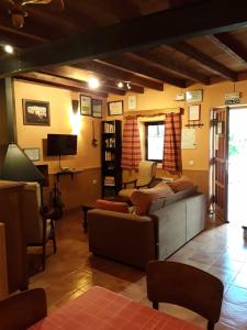 uma sala de estar com dois sofás e uma televisão em Viviendas Turísticas Los Arrayanes em Ronda