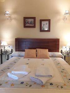 a bedroom with a large bed with two pillows at Viviendas Turísticas Los Arrayanes in Ronda