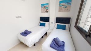 two beds in a room with blue pillows on them at Villa Mercurio - A Murcia Holiday Rentals Property in Los Alcázares