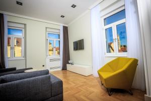 a living room with a couch and a yellow chair at Trogir Old Town Residence in Trogir