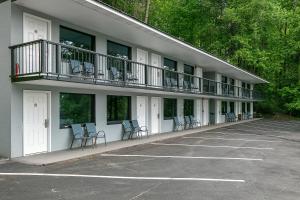 a building with chairs and a balcony in a parking lot at Gatlinburg Mountain Inn in Gatlinburg