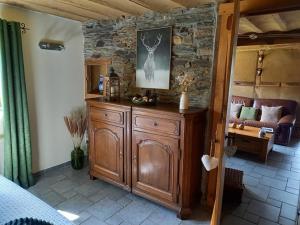 a bedroom with a wooden dresser with a deer on it at Le Clos du Cerf - Le Sous-bois in Stoumont