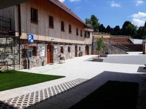 un edificio de piedra con un estacionamiento delante de él en Youth Hostel Arsviva en Stari Trg pri Ložu