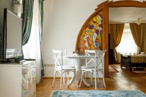 une salle à manger avec une table et des chaises blanches dans l'établissement Imperial Boutique, à Braşov