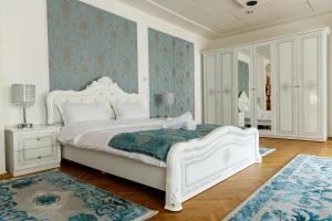 - une chambre avec un lit blanc et des murs bleus dans l'établissement Imperial Boutique, à Braşov