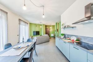 a kitchen with blue cabinets and a long table at Casa Colbert, Barolo in Barolo