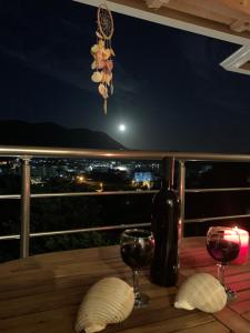 a table with a bottle of wine and two glasses at Villa Xani in Himare