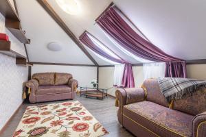 ein Wohnzimmer mit 2 Stühlen und einem Sofa in der Unterkunft Hotel Pechory-Park in Petschory