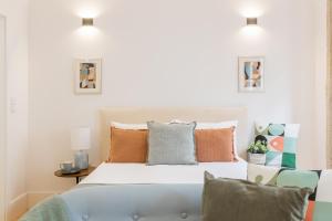 ein Schlafzimmer mit einem Bett, einem Sofa und Kissen in der Unterkunft Sol Downtown Studio in Porto