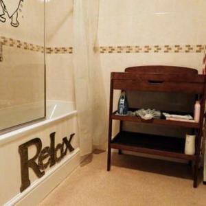 a bathroom with a bath tub and a shelf next to a shower at Kings Arms Hotel in Holsworthy