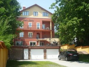 a house with a car parked in front of it at Stan és Panzió in Balatonalmádi