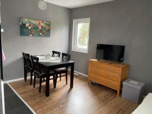 a dining room with a table with chairs and a television at Chez Mimi in Rust