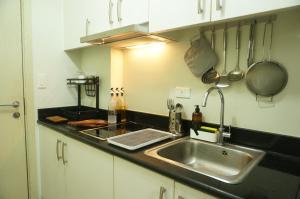 cocina con fregadero y encimera en Mint Homes in Jazz Residences Tower B, en Manila