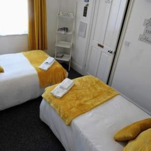 a hotel room with two beds with towels on them at Kings Arms Hotel in Holsworthy