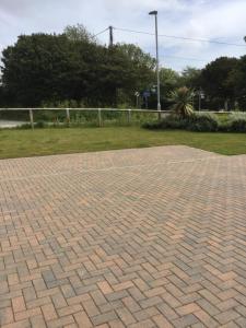 a brick paved area with a fence and grass at 2 Lapwing Drive in Hayle +2 photos