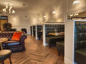 um restaurante com mobiliário de couro e mesas e cadeiras em Kilkenny House Boutique Hotel em Kilkenny