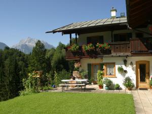 a house with a table and a balcony with flowers at Gästehaus Gmundtal in Bischofswiesen