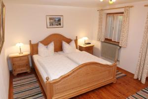 a bedroom with a wooden bed with two night stands at Gästehaus Gmundtal in Bischofswiesen