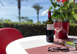una botella de vino sentada en una mesa con una copa en Sunrise Studio Marilyn, vistas jardín y mar, en Miami Platja