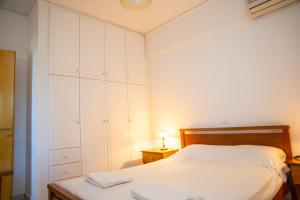 a bedroom with a bed and a dresser with a lamp at Mathia Apartments in Mathía +19 photos