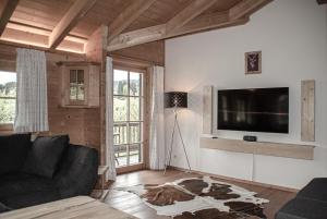 salon z kanapą i telewizorem z płaskim ekranem w obiekcie Quartier360Grad w mieście Bolsterlang