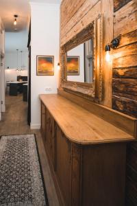 a wooden bar with a mirror on top of it at Berchy Apartment 1 in Liepāja