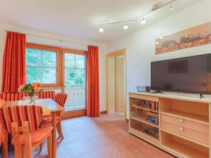 a living room with a dining room table and a television at Koglbauer - Apartment Nr 3 in Söll