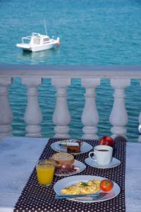 una mesa con platos de comida en un balcón con agua en Bellavista bed and breakfast, en Pag