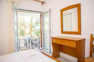 a bedroom with a dresser and a mirror and a sliding glass door at Mathia Apartments in Mathía
