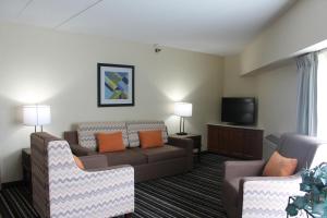 a living room with a couch and a tv at Crossroads Hotel and Huron Event Center in Huron