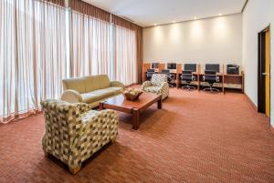 una sala de espera con sofás, mesa y sillas en Crowne Plaza Monterrey Aeropuerto, an IHG Hotel, en Monterrey