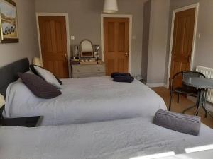 a bedroom with two beds and a table at The Coach House in Beddgelert