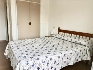 una camera con un letto e un piumone blu e bianco di ROMINA 4E - Apartamento en los canales de Roses Santa Margarita - terraza con vistas a Roses
