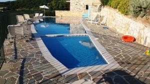 a swimming pool with chairs and an orange frisbee at Mathia Apartments in Mathía