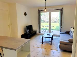 un soggiorno con divano e tavolo di Charmant appartement avec terrasse et jardin au calme Proche Bus Métro a Tolosa