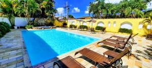 a large swimming pool with chairs and a resort at Pousada Estrela de Paraty in Paraty