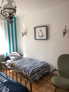 a bedroom with a bed and a chair and a chandelier at Appartement à Le Portel in Le Portel