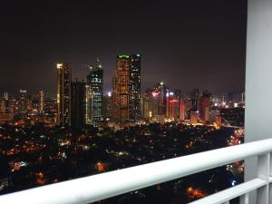 Blick auf die Stadt in der Nacht mit Lichtern in der Unterkunft Mint Homes in Jazz Residences Tower B in Manila