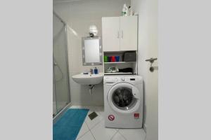 La salle de bains est pourvue d'un lave-linge et d'un lavabo. dans l'établissement Apartment Gema - One bedroom apartment, à Izola