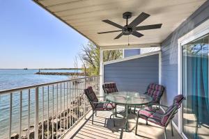 un porche con mesa, sillas y el océano en Cozy Middle Bass Island Getaway On Lake Eerie!, en Put-in-Bay