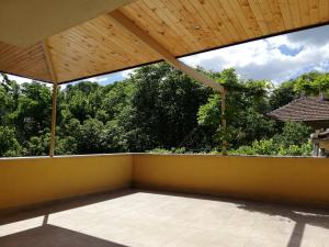 an empty balcony with a wooden roof with trees at The Yellow House in Stara Zagora
