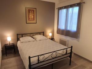 una camera da letto con un letto con due lampade e una finestra di Charmant appartement avec terrasse et jardin au calme Proche Bus Métro a Tolosa