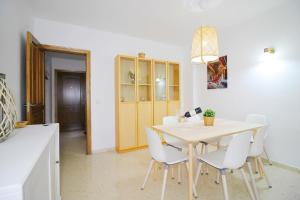 une salle à manger avec une table et des chaises blanches dans l'établissement Apartment Avenida Miramar, à Fuengirola