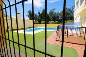 - une vue sur la piscine à travers une clôture dans l'établissement Apartment Avenida Miramar, à Fuengirola