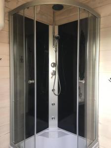 a shower with a glass enclosure in a bathroom at 83 Bredynki in Biskupiec