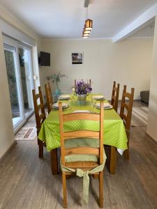 mesa de comedor con mantel verde y sillas de madera en Haus zum See en Zwenkau