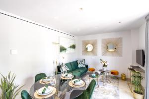 uma sala de estar com um sofá verde e uma mesa em MARBELLA BANUS SUITES - Bird Of Paradise Playas del Duque Banús Suite Apartment em Marbella
